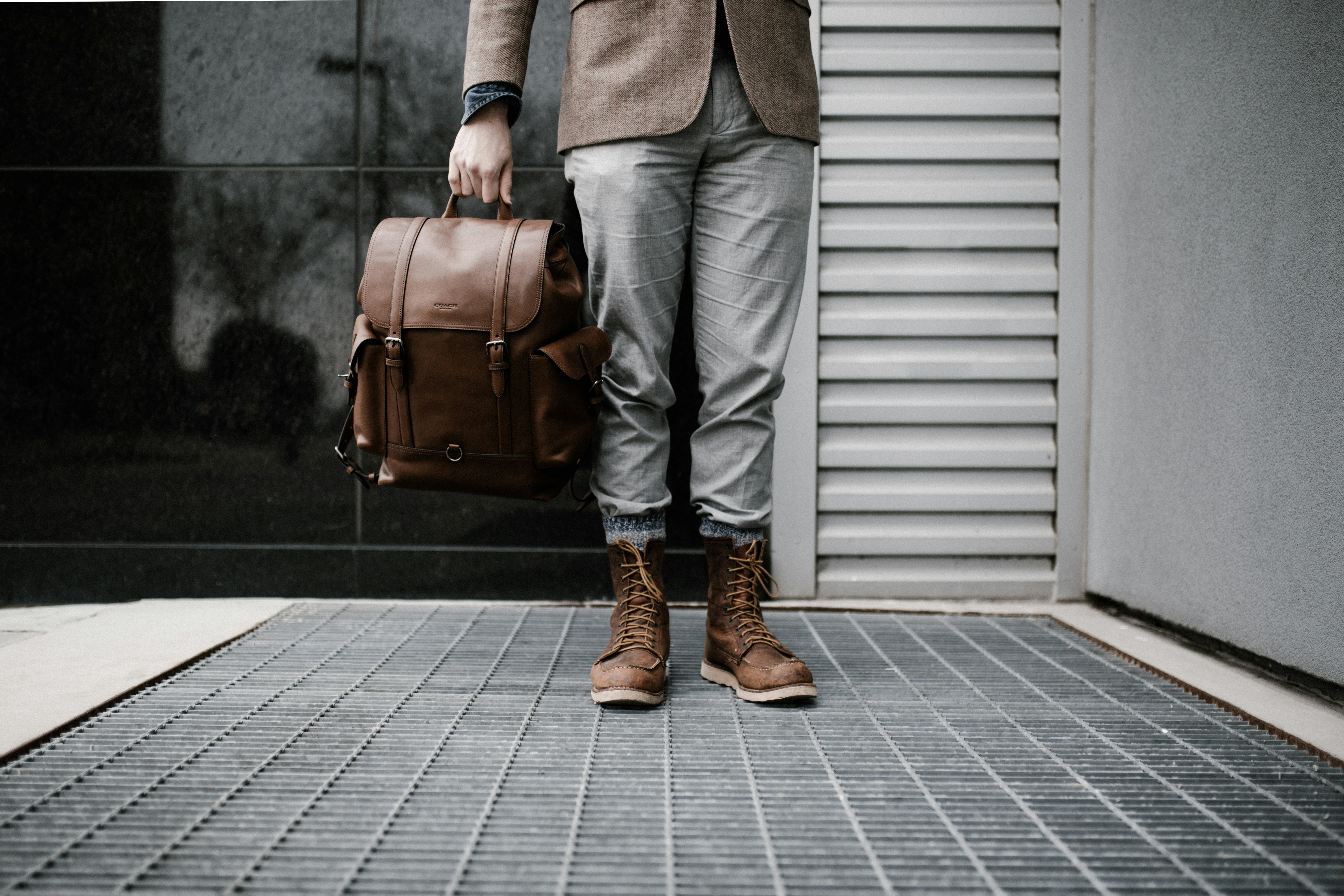 person holding brown leather bag